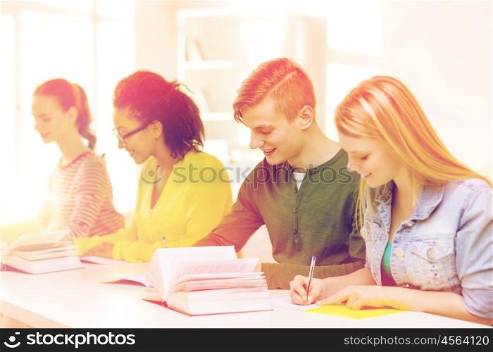 education and school concept - five smiling students with textbooks and books at school. students with textbooks and books at school