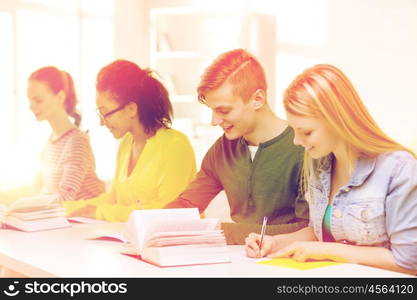 education and school concept - five smiling students with textbooks and books at school. students with textbooks and books at school