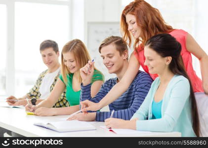 education and school concept - five smiling students with textbooks and books at school