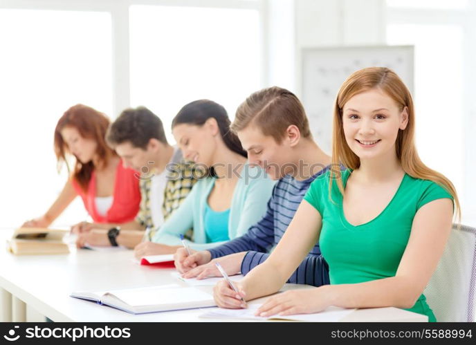 education and school concept - five smiling students with textbooks and books at school