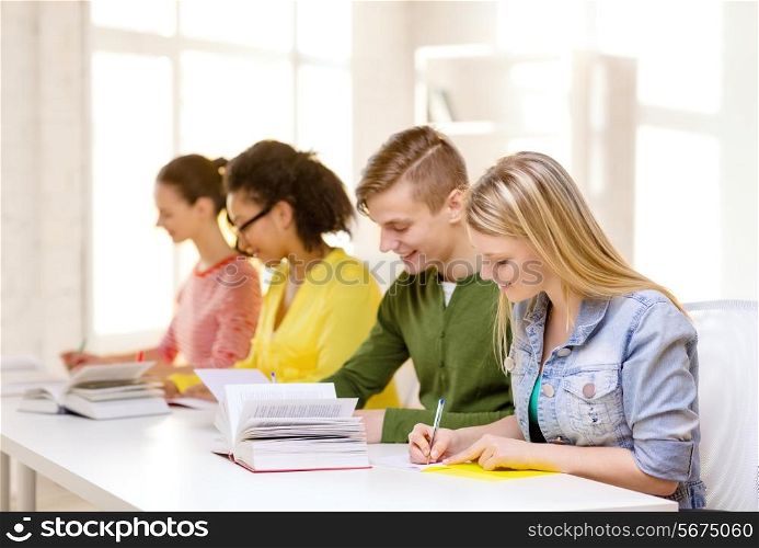 education and school concept - five smiling students with textbooks and books at school