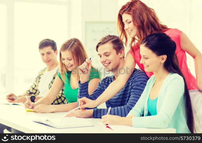 education and school concept - five smiling students with textbooks and books at school