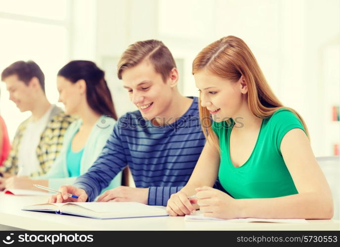 education and school concept - five smiling students with textbooks and books at school