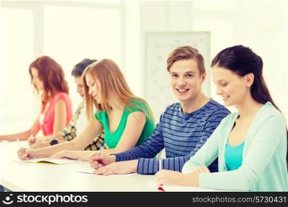 education and school concept - five smiling students with textbooks at school