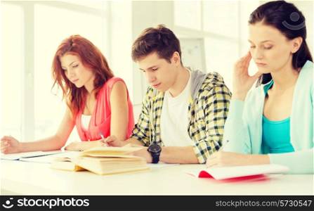 education and school concept - five tired students with textbooks and books at school