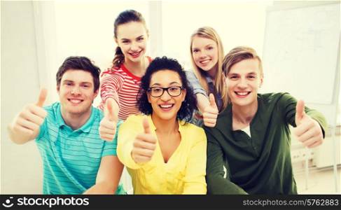 education and school concept - group of smiling students at school showing thumbs up