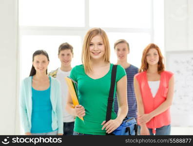 education and school concept - group of smiling students with teenage girl in front with bag and folders