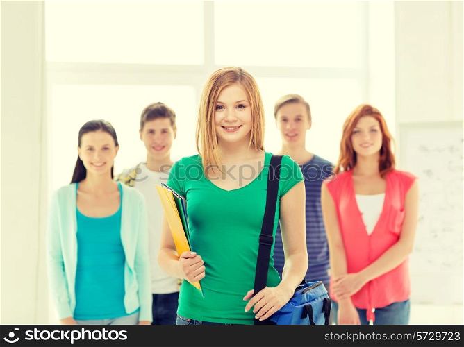 education and school concept - group of smiling students with teenage girl in front with bag and folders
