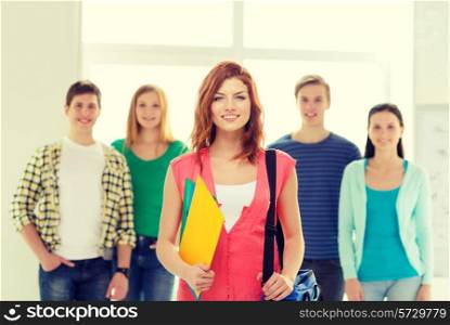 education and school concept - group of smiling students with teenage girl in front with bag and folders
