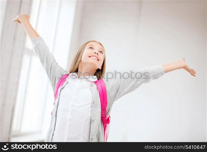 education and school concept - happy and smiling teenage girl with raised hands