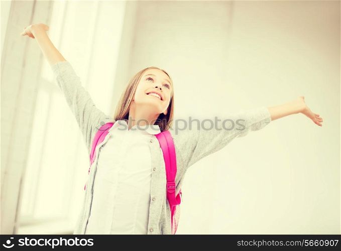 education and school concept - happy and smiling teenage girl with raised hands