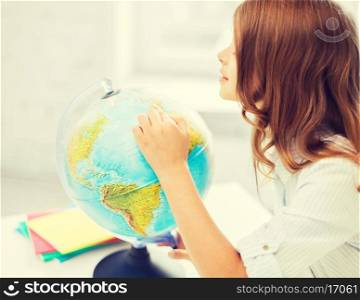 education and school concept - little curious student girl with globe at school