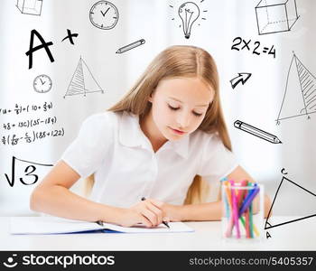 education and school concept - little student girl drawing at school