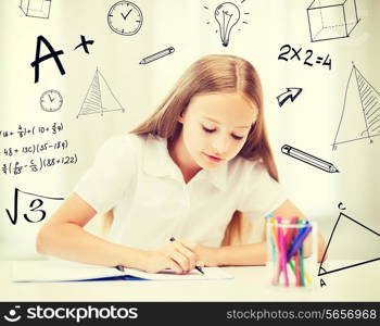 education and school concept - little student girl drawing at school