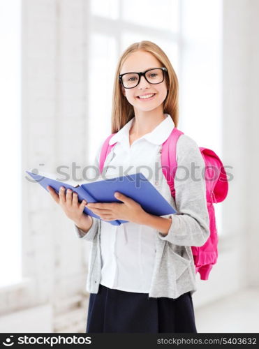 education and school concept - little student girl reading book at school