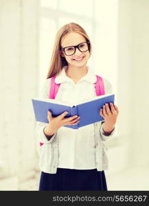 education and school concept - little student girl reading book at school