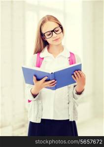 education and school concept - little student girl reading book at school