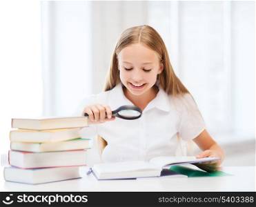 education and school concept - little student girl reading book with magnifier at school