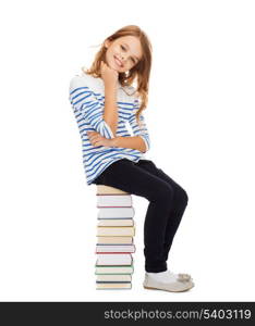 education and school concept - little student girl sitting on stack of books