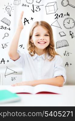 education and school concept - little student girl studying and raising hand at school