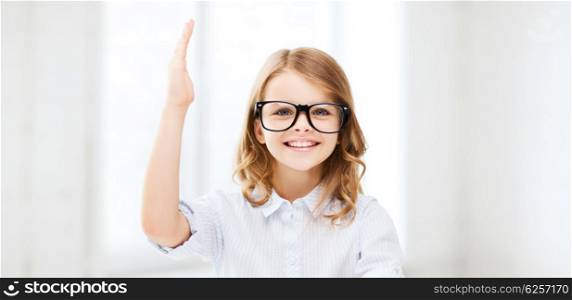 education and school concept - little student girl studying and raising hand at school. student girl studying at school