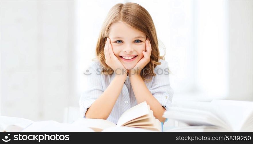 education and school concept - little student girl studying and reading book at school. student girl studying at school