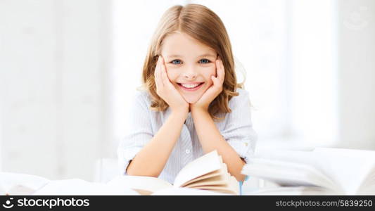 education and school concept - little student girl studying and reading book at school. student girl studying at school