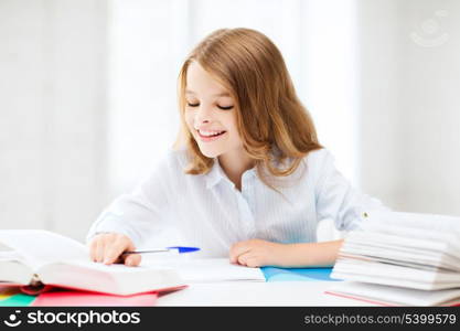 education and school concept - little student girl studying at school