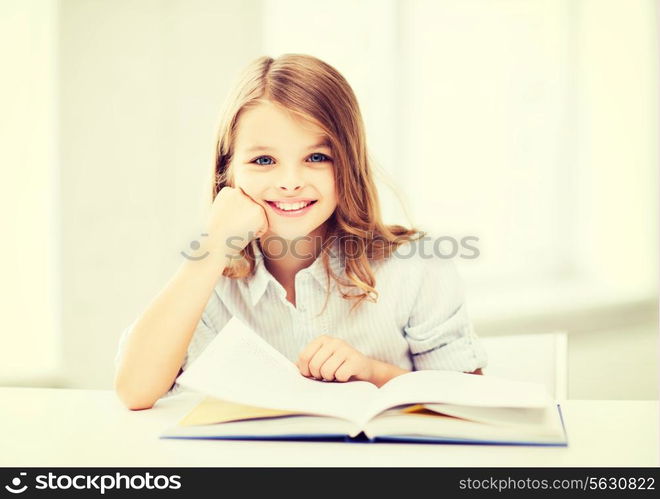 education and school concept - little student girl studying at school