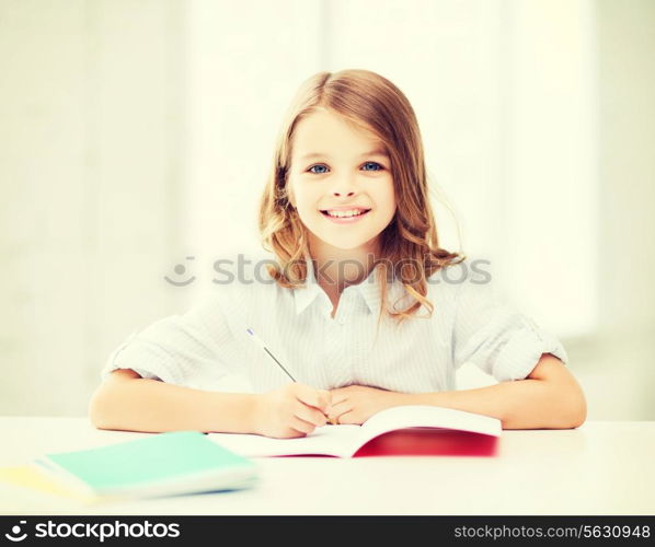 education and school concept - little student girl studying at school