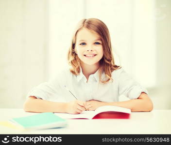 education and school concept - little student girl studying at school