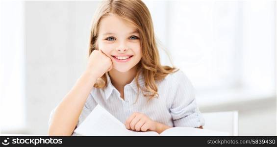 education and school concept - little student girl studying at school. little student girl studying at school