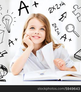 education and school concept - little student girl studying at school. little student girl studying at school