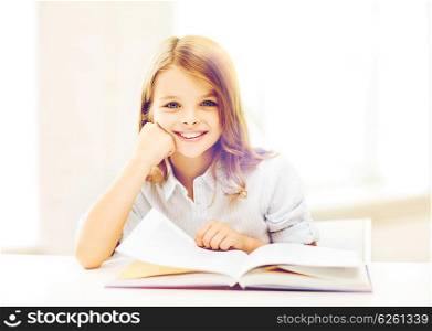 education and school concept - little student girl studying at school. little student girl studying at school