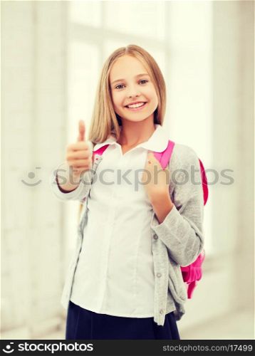 education and school concept - little student girl with bag showing thumbs up at school