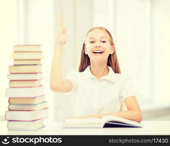 education and school concept - little student girl with books raising hand up at school