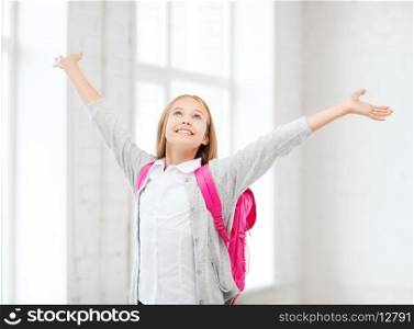 education and school concept - little student girl with hands up at school