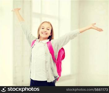 education and school concept - little student girl with hands up at school