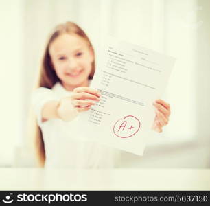 education and school concept - little student girl with test and A grade at school showing thumbs up