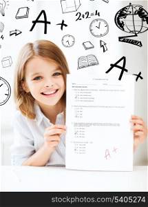 education and school concept - little student girl with test and A grade at school