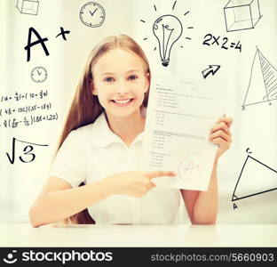 education and school concept - little student girl with test and A grade at school