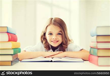 education and school concept - smiling little student girl with many books at school