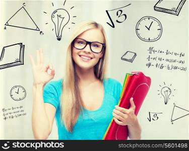 education and school concept - smiling student with folders showing ok sign