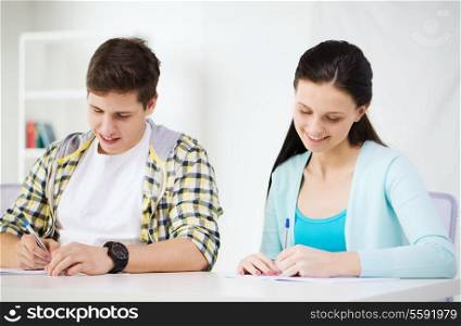 education and school concept - two smiling students with textbooks at school