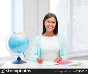 education and school, travel concept - female teacher with globe and notepad