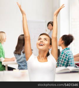 education and success concept - happy student girl with hands up