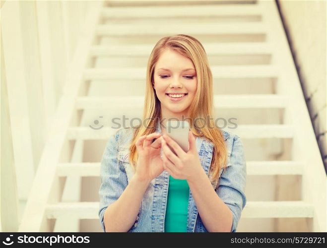 education and technology concept - smiling female student with smartphone sitting on staircase