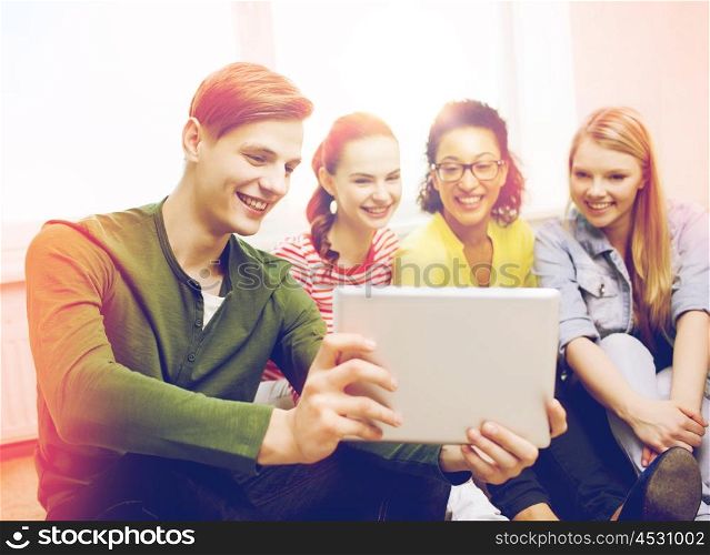 education and technology concept - smiling students making picture with tablet pc computer at home. smiling students making picture with tablet pc