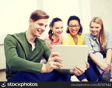 education and technology concept - smiling students making picture with tablet pc computer at home