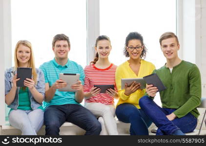 education and technology concept - smiling students with tablet pc computer at school